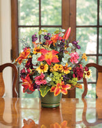 Lily, Ranunculus & Berries Faux Flower Centerpiece on a wooden table.
