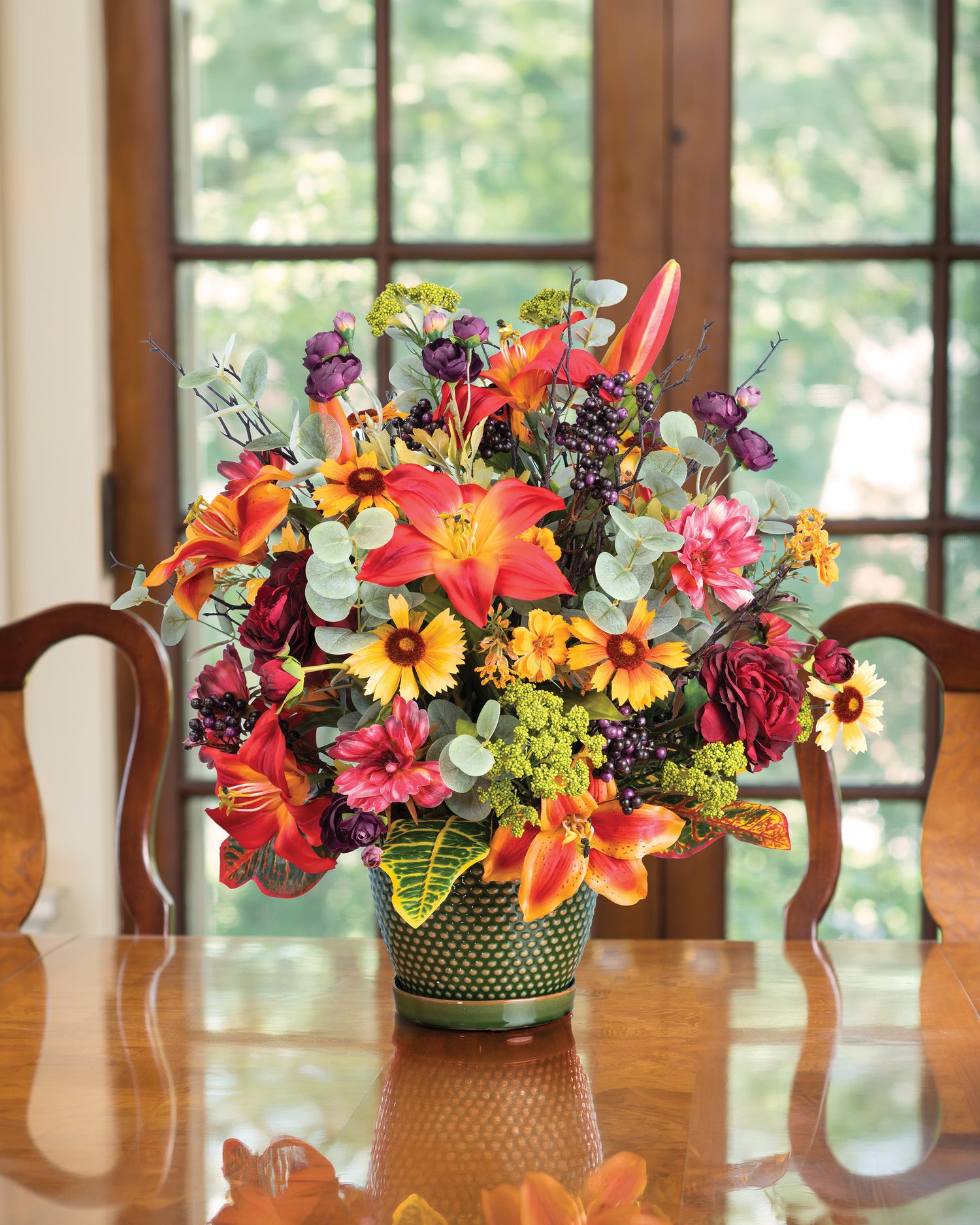 Lily, Ranunculus & Berries Faux Flower Centerpiece on a wooden table.