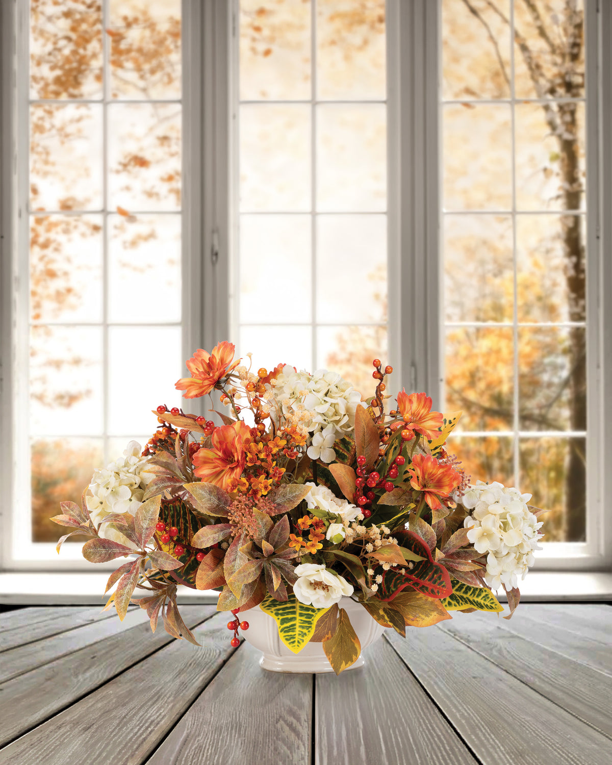 Hydrangeas & Coreopsis Faux Flower Centerpiece. autumn foliage hydrangeas, wild roses, orange coreopsis and berries in an 8” oval ceramic planter set on a table.