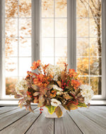Hydrangeas & Coreopsis Faux Flower Centerpiece. autumn foliage hydrangeas, wild roses, orange coreopsis and berries in an 8” oval ceramic planter set on a table.