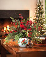 Ruscus & Berry Faux Christmas Cardinal Accent, set in Metal Cardinal Pot  on a wooden table and Christmas Tree in the background.