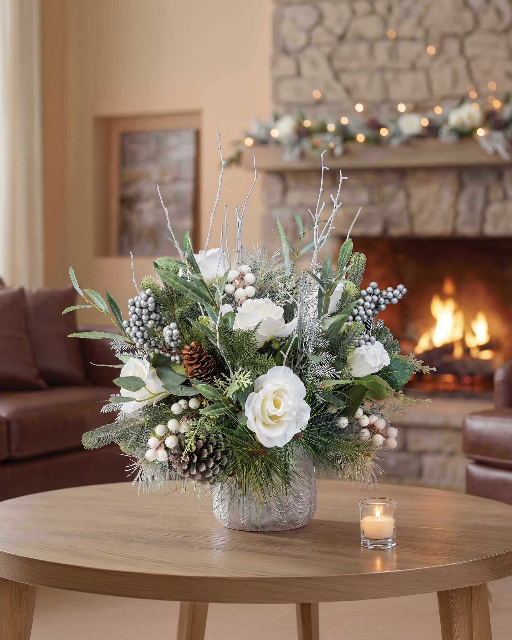 Winter White & Silver Artificial Holiday Centerpiece, set in Tree Embossed Pot, in front of a fireplace.