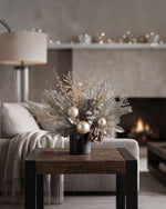 Champagne Elegance Artificial Holiday Accent in Ceramic Cylinder Vase, on a wooden table with cream white lifestyle setting.